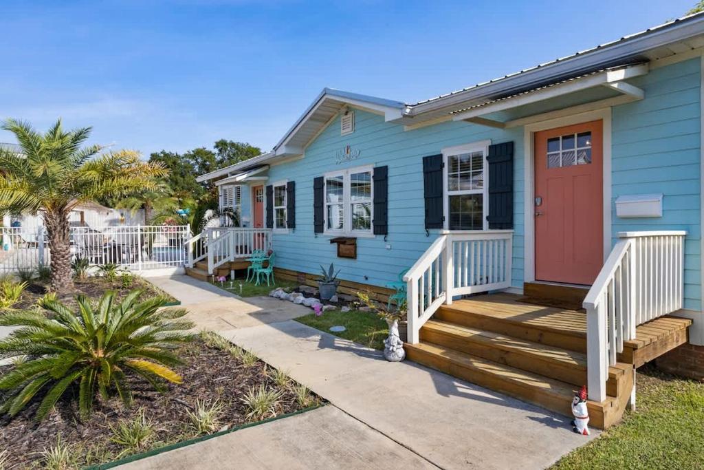 a blue house with a red door at Suite - Knome Dome with Shared Pool in Bay Saint Louis