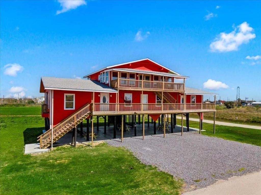 a large red house with a large deck at 6 Bedroom, 3 unit Triplex in Crystal Beach in Port Bolivar