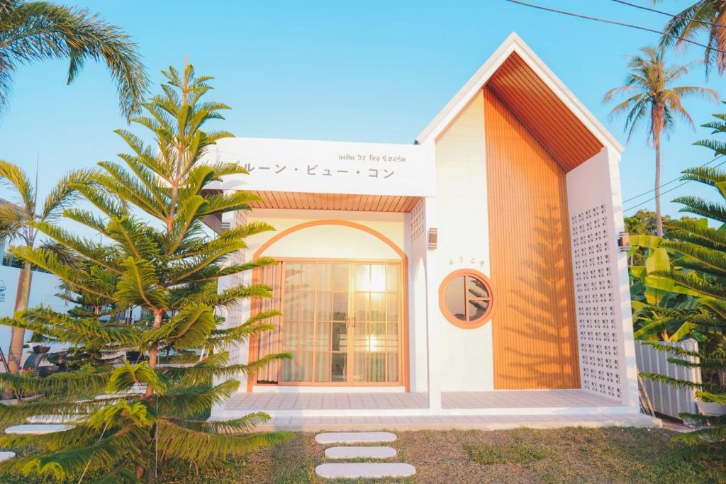 a house with a palm tree in front of it at เพลินวิวโขงรีสอร์ท Plearnviewkhongresort in Ban Nong Mum