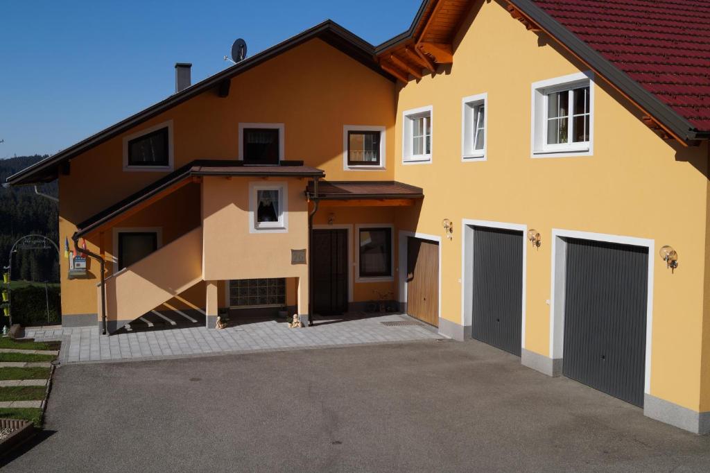DorfstettenにあるFerienwohnung Höbartの二つのガレージドアと私道のある家