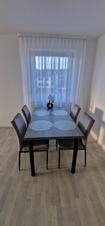 a dining room table with chairs and a window at Boxspring Apartment Rottweil mit Stellplatz in Rottweil