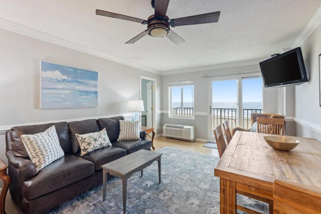 a living room with a couch and a table at Oceanfront Condo, Heated Pool, Fitness Center in Virginia Beach
