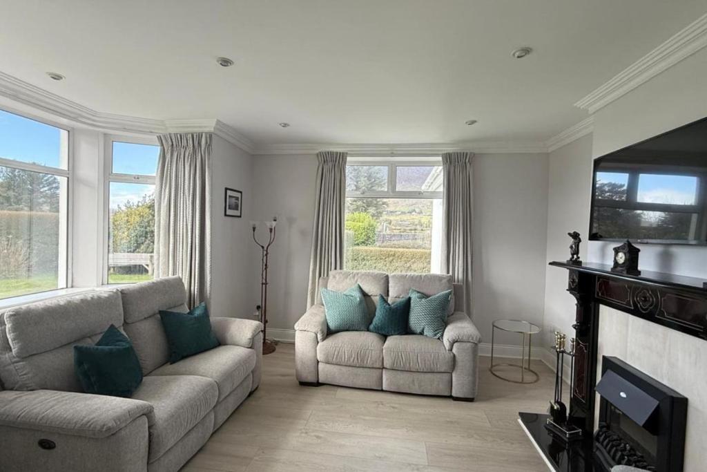 a living room with two couches and a television at Greenway Riverside House - Cahersiveen in Foilmore Bridge