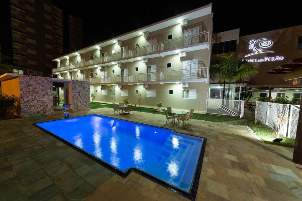 a hotel with a large swimming pool in front of a building at Hotel do Feijão in Cachoeira Paulista