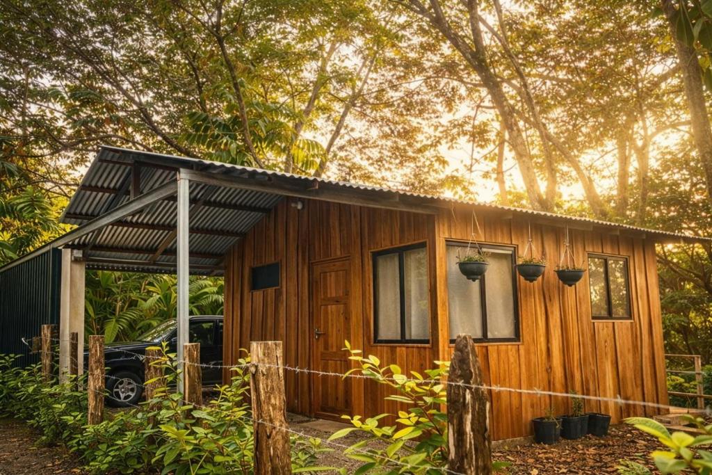 a small wooden house with a fence in front of it at Mayra Campground in Savegre