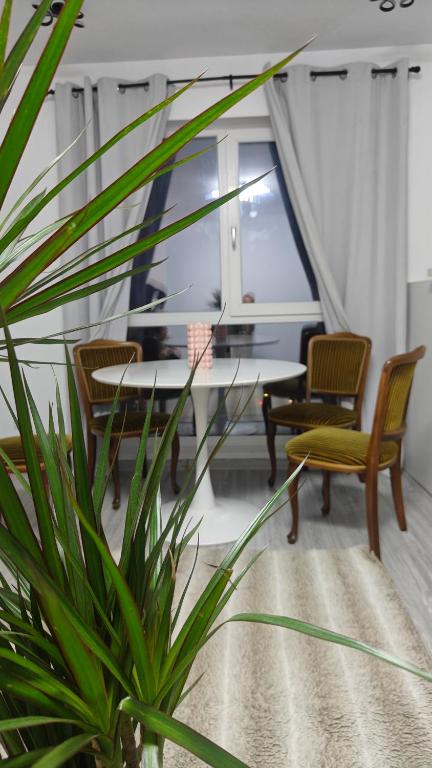 a dining room with a table and chairs and a plant at Ultracentral Piata in Caracal