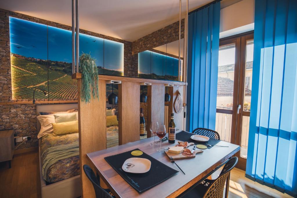 a dining room with a table and a bed at Appartamento Alba centro storico in Alba
