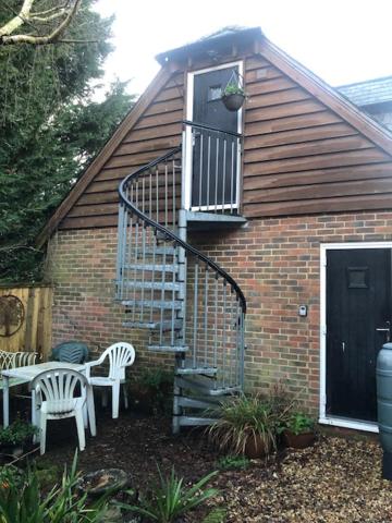a brick house with a staircase and a balcony at Hackamore House in Salisbury