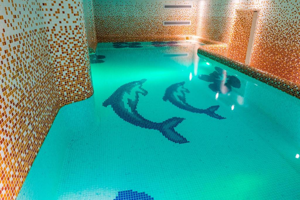 una persona che nuota in una piscina con squali disegnati sull'acqua di Hotel Boutique Belvedere a Sinaia