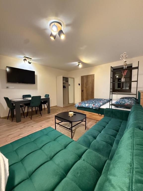 a living room with a green couch and a table at Apartmán Mia 1 in Liptovský Mikuláš