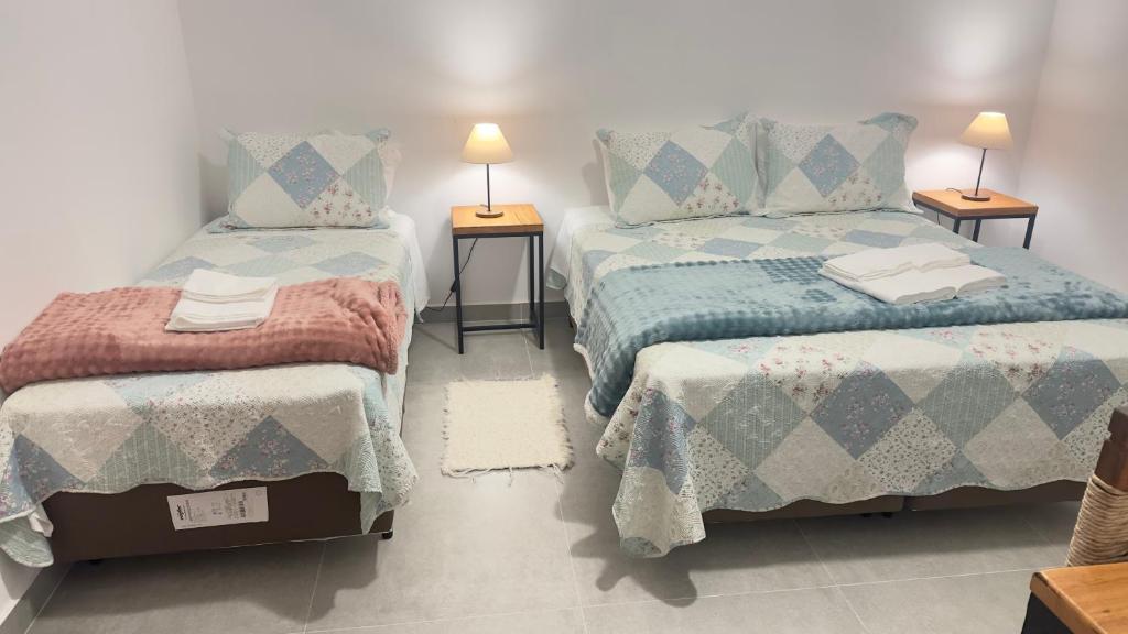 a bedroom with two beds and two lamps on tables at Pouso do Rancho in São José do Barreiro