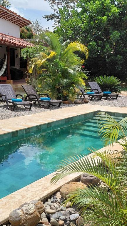 a swimming pool with chairs next to a resort at Casa Alamanda B&B in Barichara