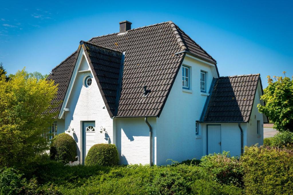 a white house with a black roof at Das Sonnenhaus in Lindaunis