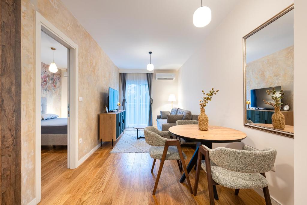a living room with a table and chairs in a room at Fratello Apartment in Podgorica