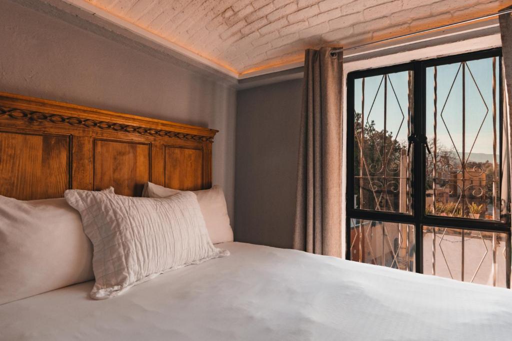 a bedroom with a bed and a large window at Casa Xaca in San Miguel de Allende