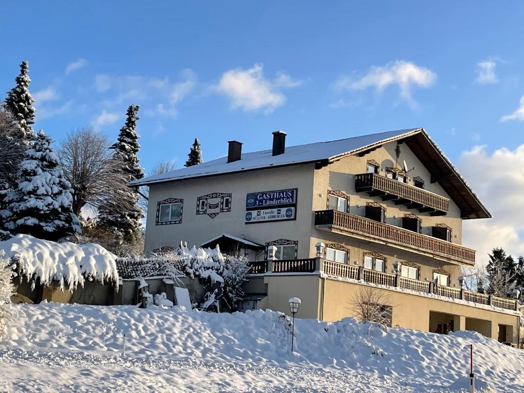 a building with snow on the ground in front of it at Gästehaus 3-Länderblick-Panoramablick in Mönichkirchen