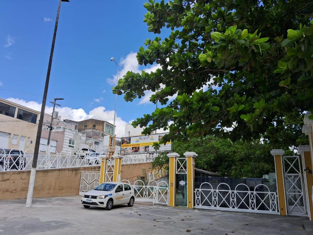 a white car parked in a parking lot at Pousada Palladium in Neópolis