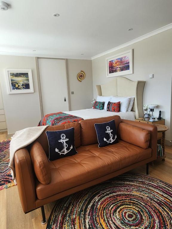 a bedroom with a bed with a brown leather couch at Anchors Aweigh in Stanley