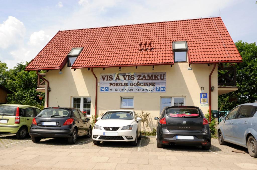 a building with cars parked in a parking lot at B&B vis a vis Zamku in Malbork