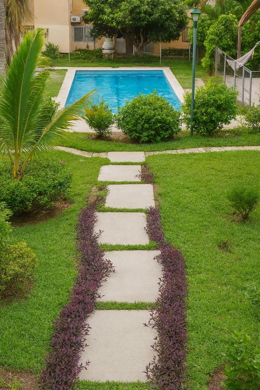 a stepping stone path leading to a swimming pool at Two-bedroom condo Ground floor in Santa Cruz Huatulco