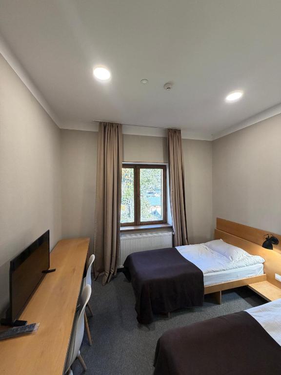 a bedroom with a bed and a desk and a television at Art House Mestia in Mestia