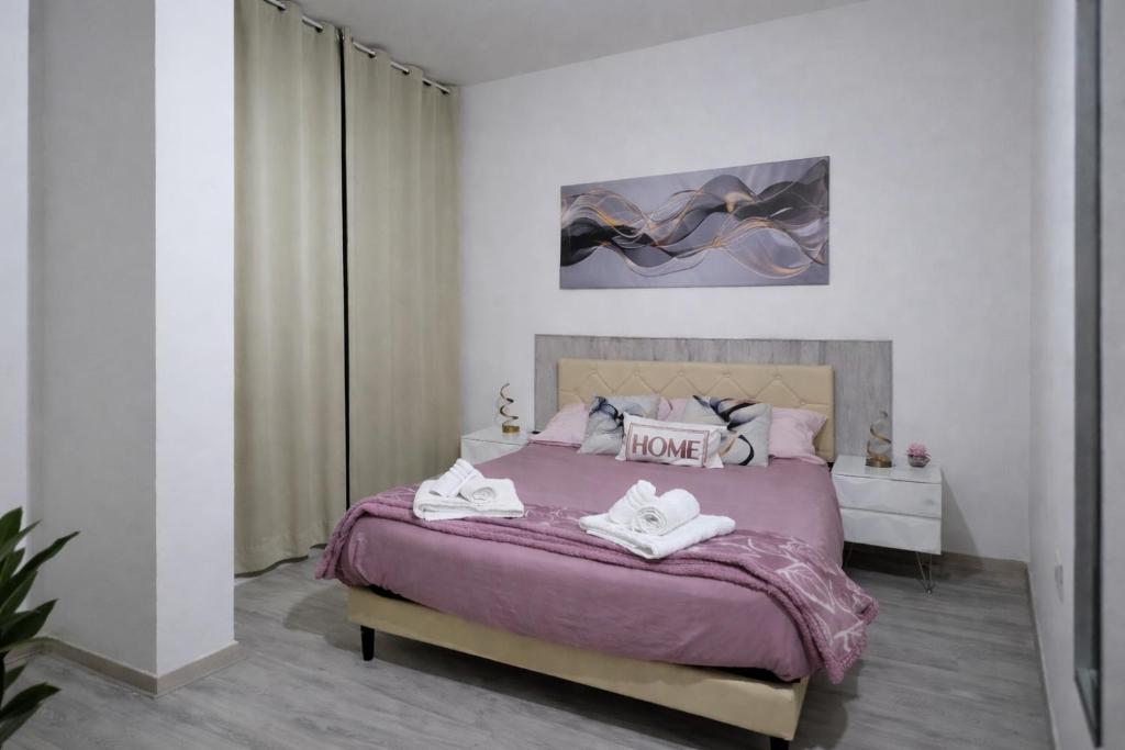 a bedroom with a purple bed with two towels on it at Casa Nicole in Assemini