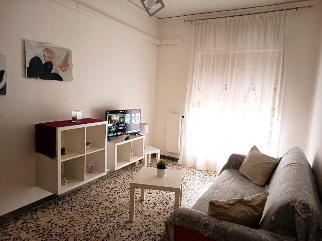 a living room with a couch and a tv and a window at Casa Lodi Casavacanze in Eboli