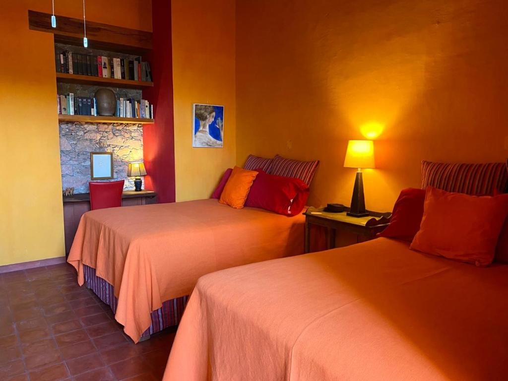 a bedroom with two beds and a desk with a lamp at Posada de la cruz #4 in Querétaro