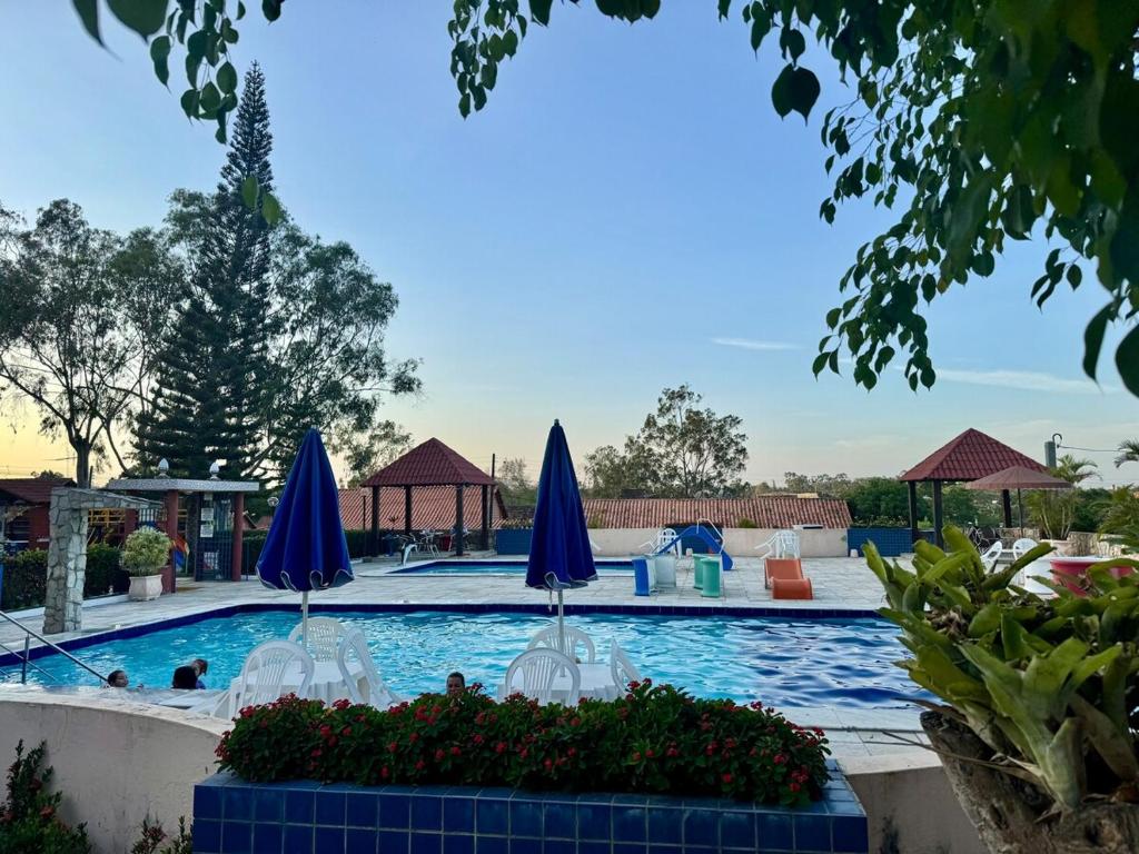 a swimming pool with blue and white umbrellas at Casa com Piscina em Gravatá Carnaval in Gravatá
