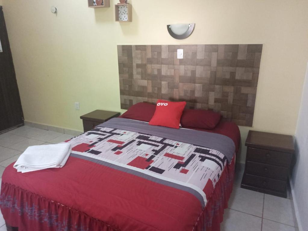 a bedroom with a large bed with red pillows at Casa Corozo in Bacalar