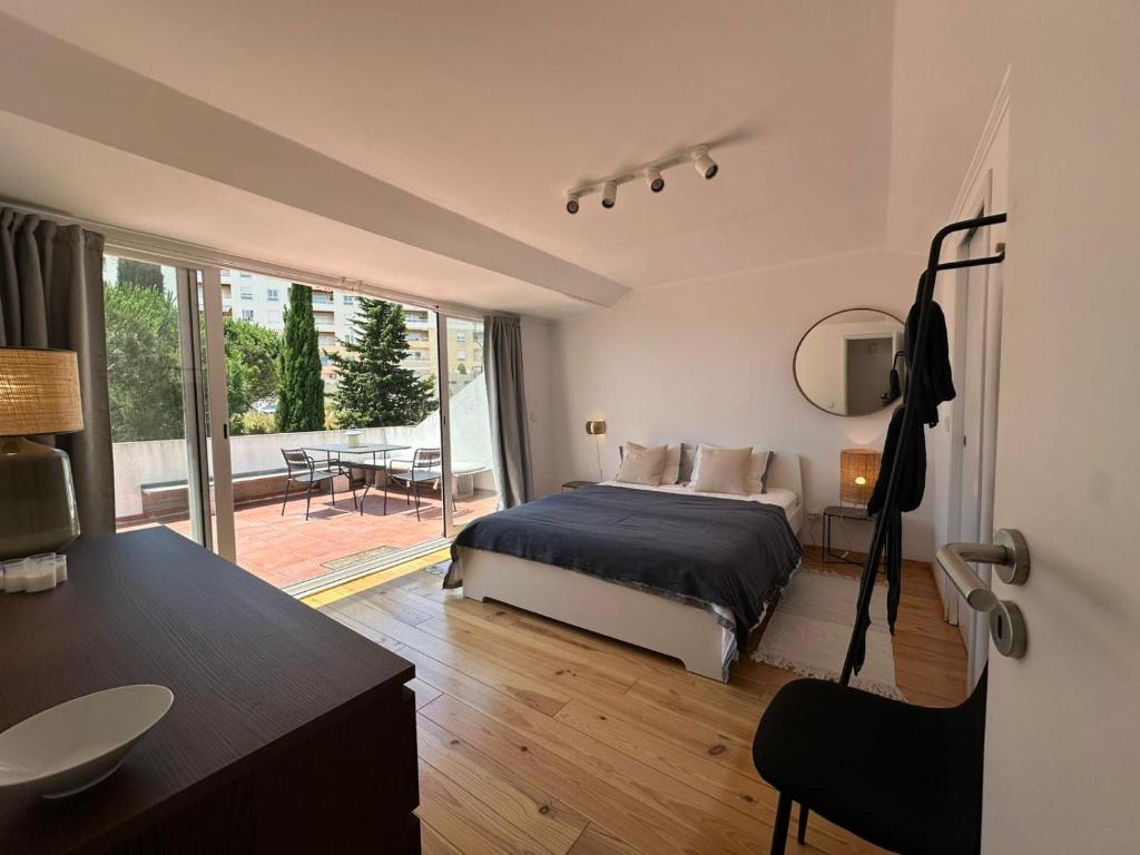 a bedroom with a bed and a view of a patio at Suite privativa em apartamento em Algés, Lisboa in Algés