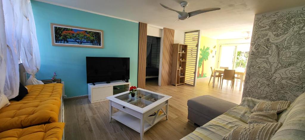 a living room with a couch and a flat screen tv at Escale caraibe in Le Gosier
