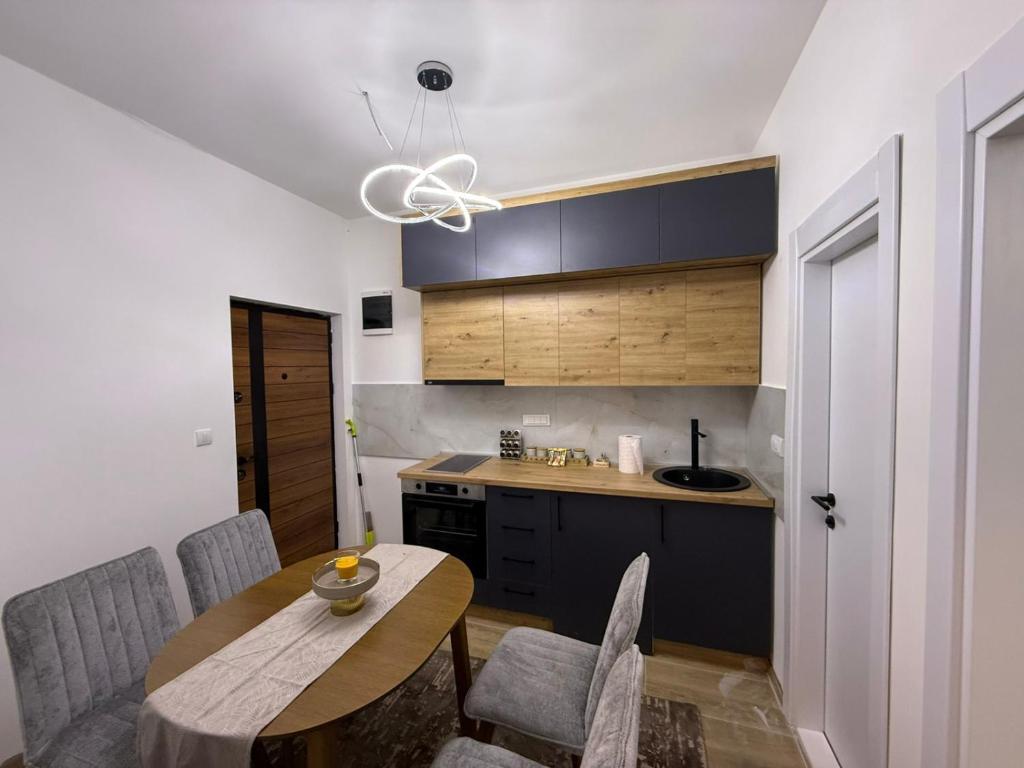 a kitchen with a wooden table and chairs and a kitchen with a sink at Apartman Djurdja in Raška
