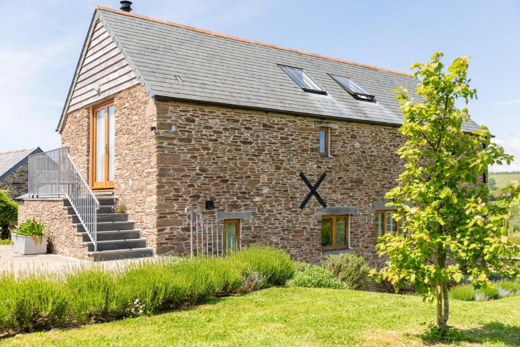 a stone house with a clock on the side of it at 3 Bed in Loddiswell oc-t34185 in Churchstow