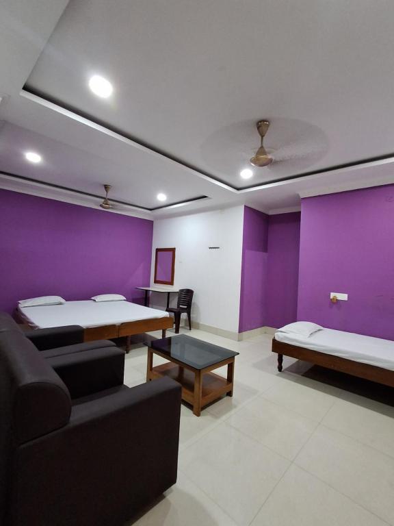 a room with two beds and a couch and a table at Hotel New Castle in Guwahati