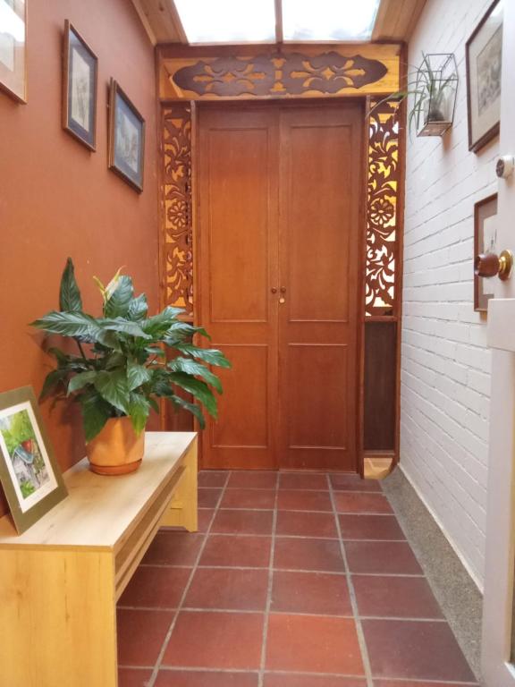 a hallway with a wooden door and a potted plant at Rincon Acogedor in Bogotá