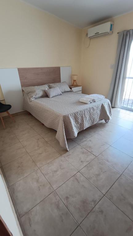 a bedroom with a bed and a tiled floor at Once Reinas Departamentos in San Rafael