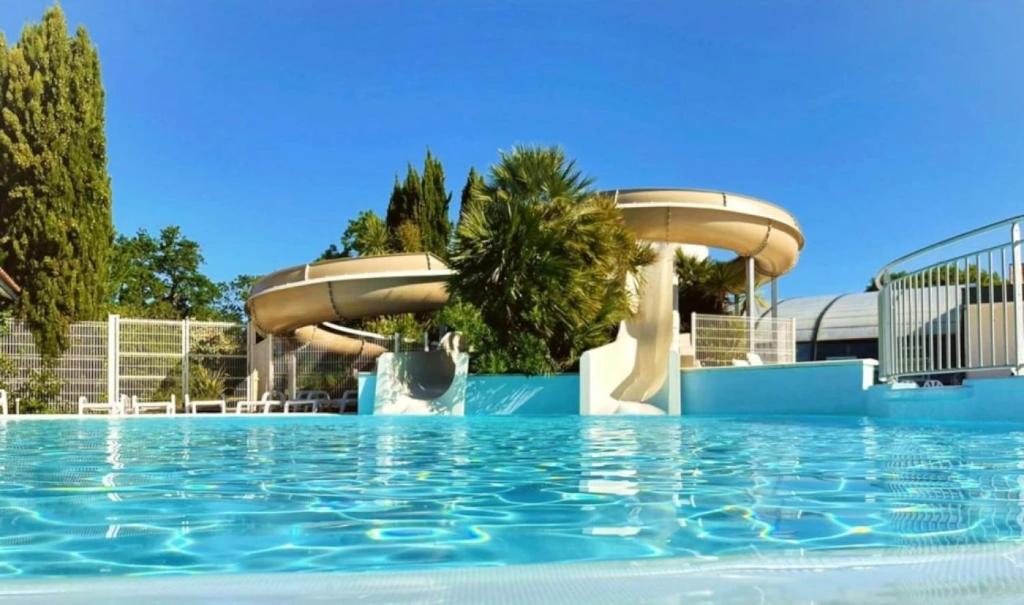 a pool at a resort with two water fountains at ZEcamping 4 étoiles avec parc aquatique - sauna et hammam in Sanguinet