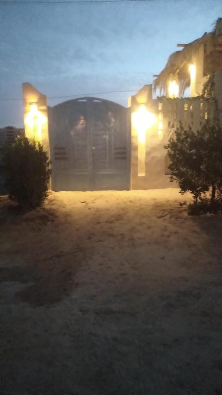 a building with lights on the side of it at night at Fekry house in Qaryat Ḩātim aţ Ţāʼī