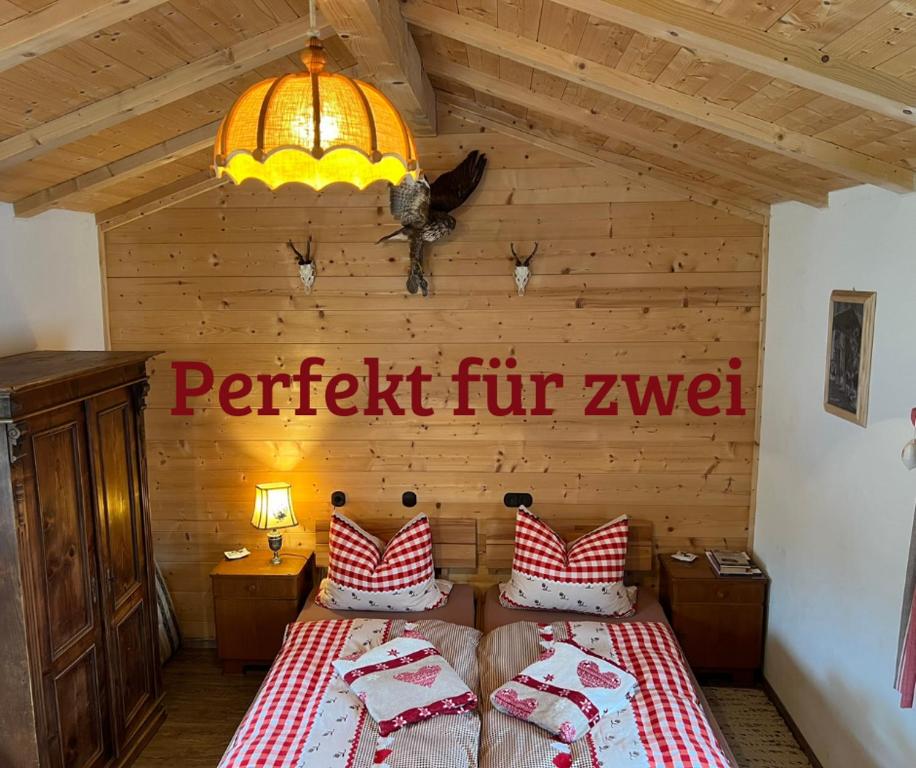 a bedroom with a bed and a sign on the wall at Chalet Berghaus Rusch in Blaichach