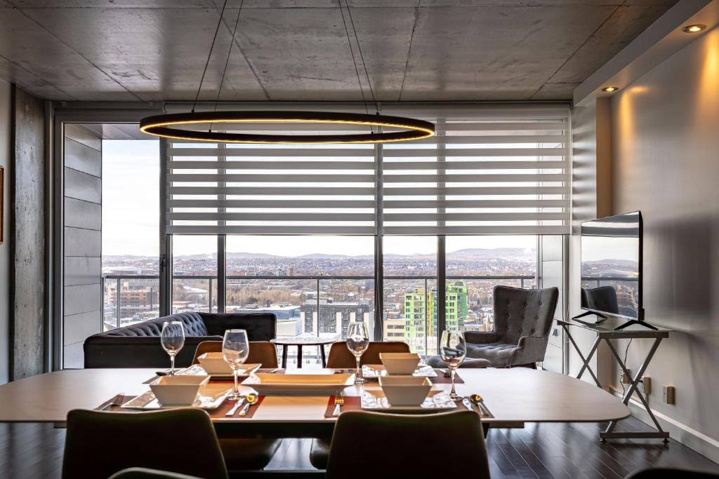 a dining room with a table and chairs and a large window at Les Immeubles Charlevoix - Le 760-415 in Quebec City