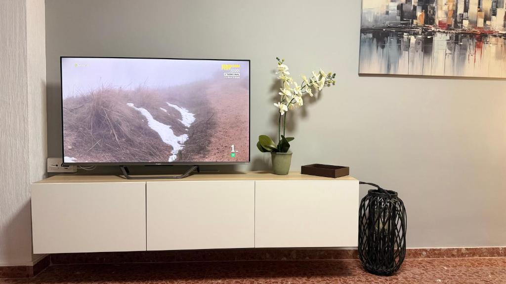 a flat screen tv sitting on a white cabinet at Puerta del Mar 2 in Adra