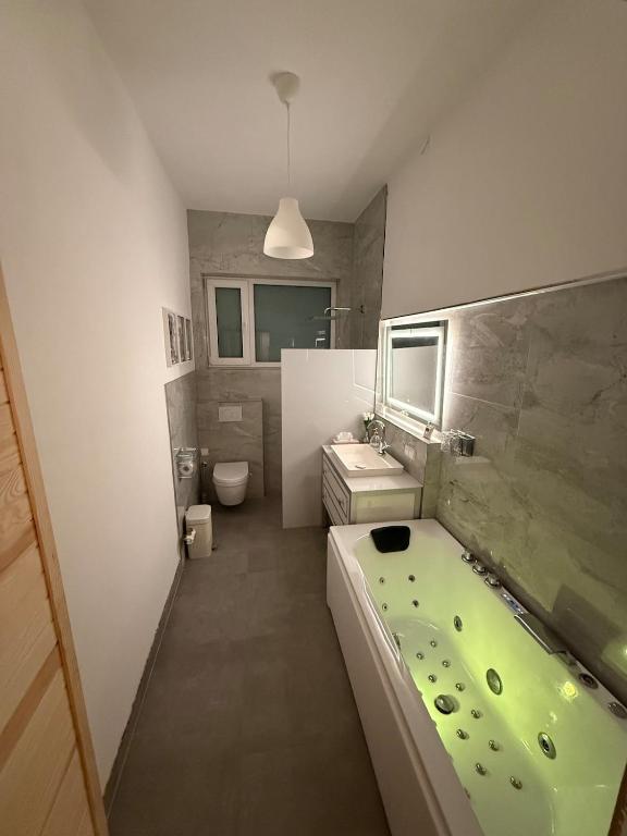 a bathroom with a green tub and a sink at 35qm2, Whirlpool & Queensize-Bett, Terrasse 50qm2, Self-Checkin, eigener Parkplatz, Nähe Ulm und Universität in Blaustein