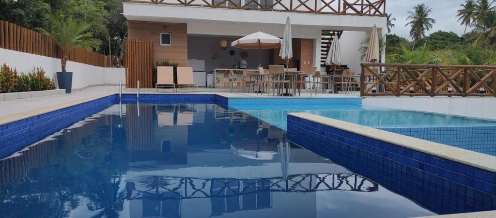 a swimming pool with blue tiles in a house at Casa Mobiliada - Praia Imbassaí in Imbassai