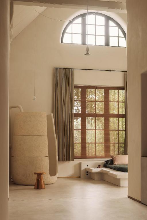 a bedroom with a bed and a large window at Jonojé Luxury Suites in Bruges