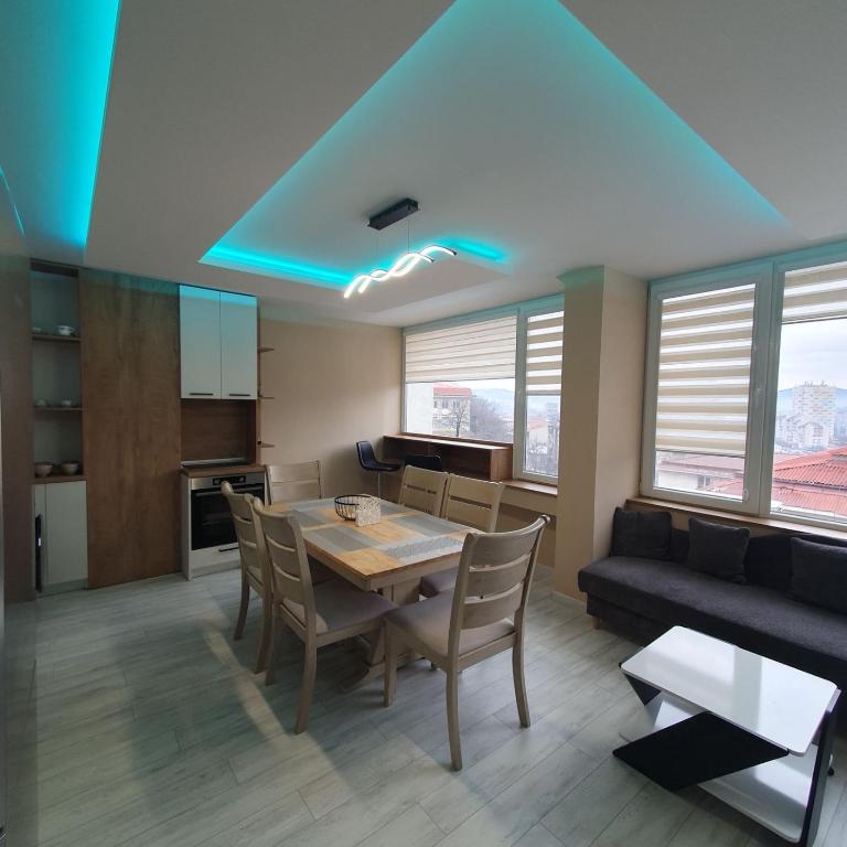 a kitchen and dining room with a table and a couch at Grand Central Gabrovo in Gabrovo