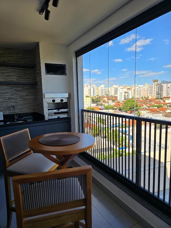 a balcony with a table and a view of a city at Emilie Home in Sao Jose do Rio Preto