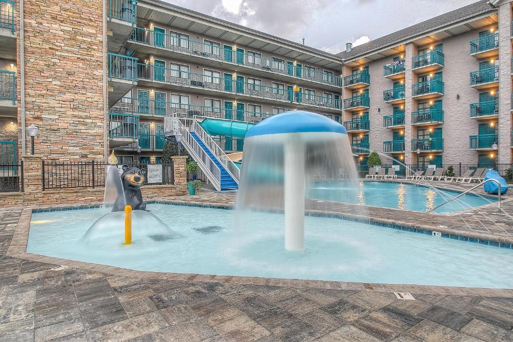 a pool with a water slide in front of a building at Accommodations By Willow Brook Lodge in Pigeon Forge