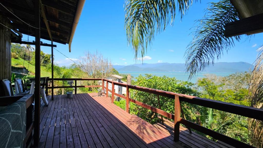 a wooden deck with a view of the ocean at Casa ceu in Florianópolis