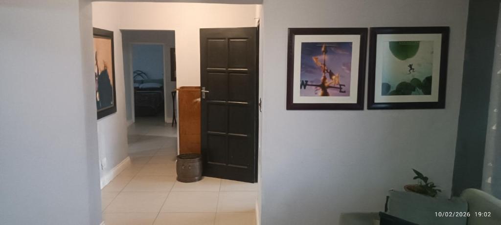 a hallway with two pictures on the wall and a door at Bushman Kraal Lux in Soweto